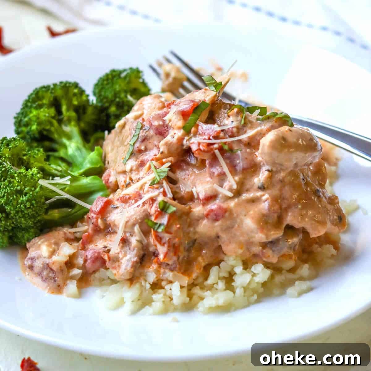 Slow cooked chicken thighs served over riced cauliflower with creamy tomato sauce.