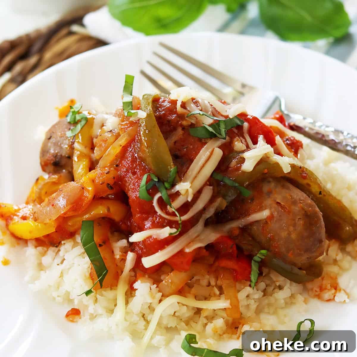 Sausage and peppers garnished with fresh basil and parmesan.