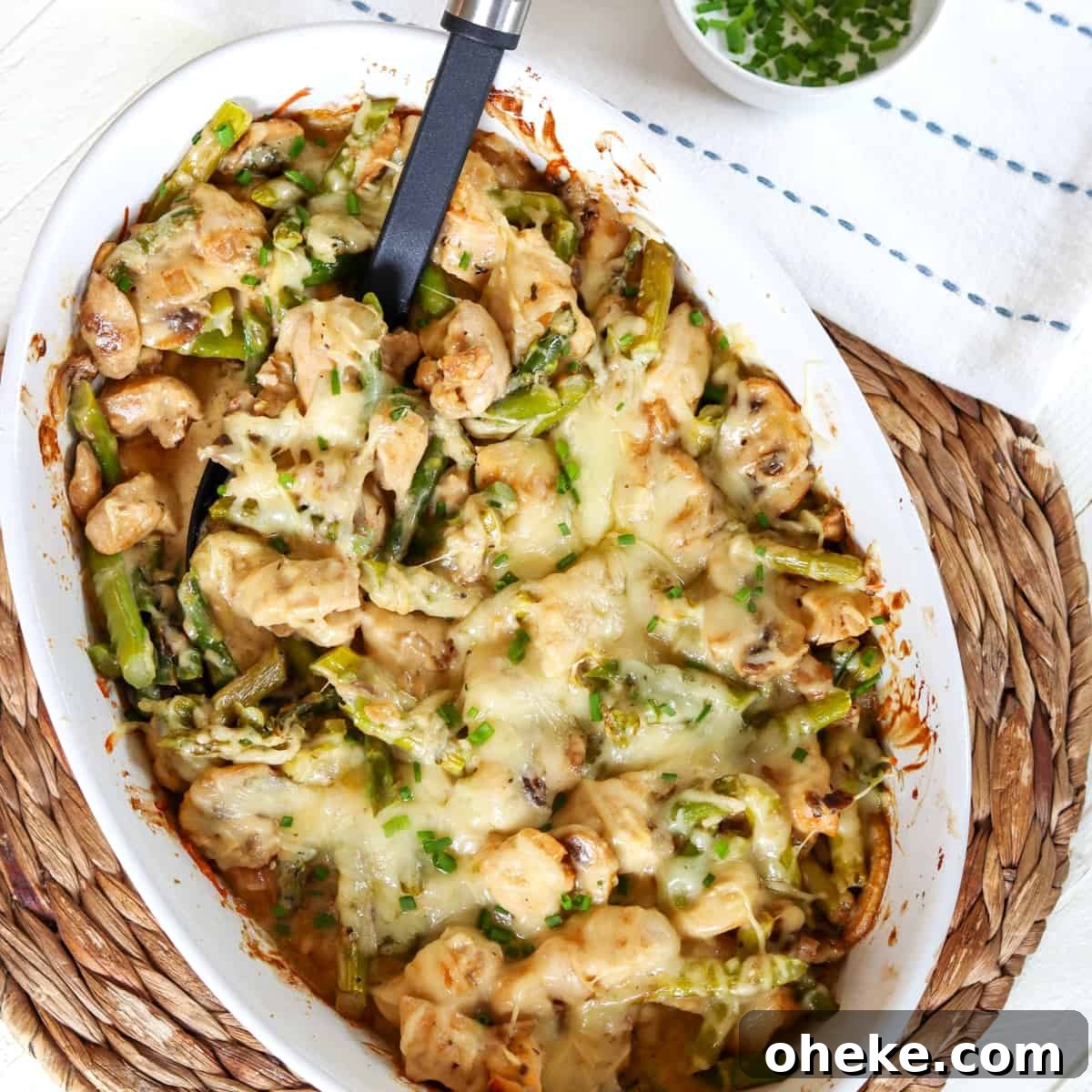 a white oval casserole dish with asparagus and chicken casserole.