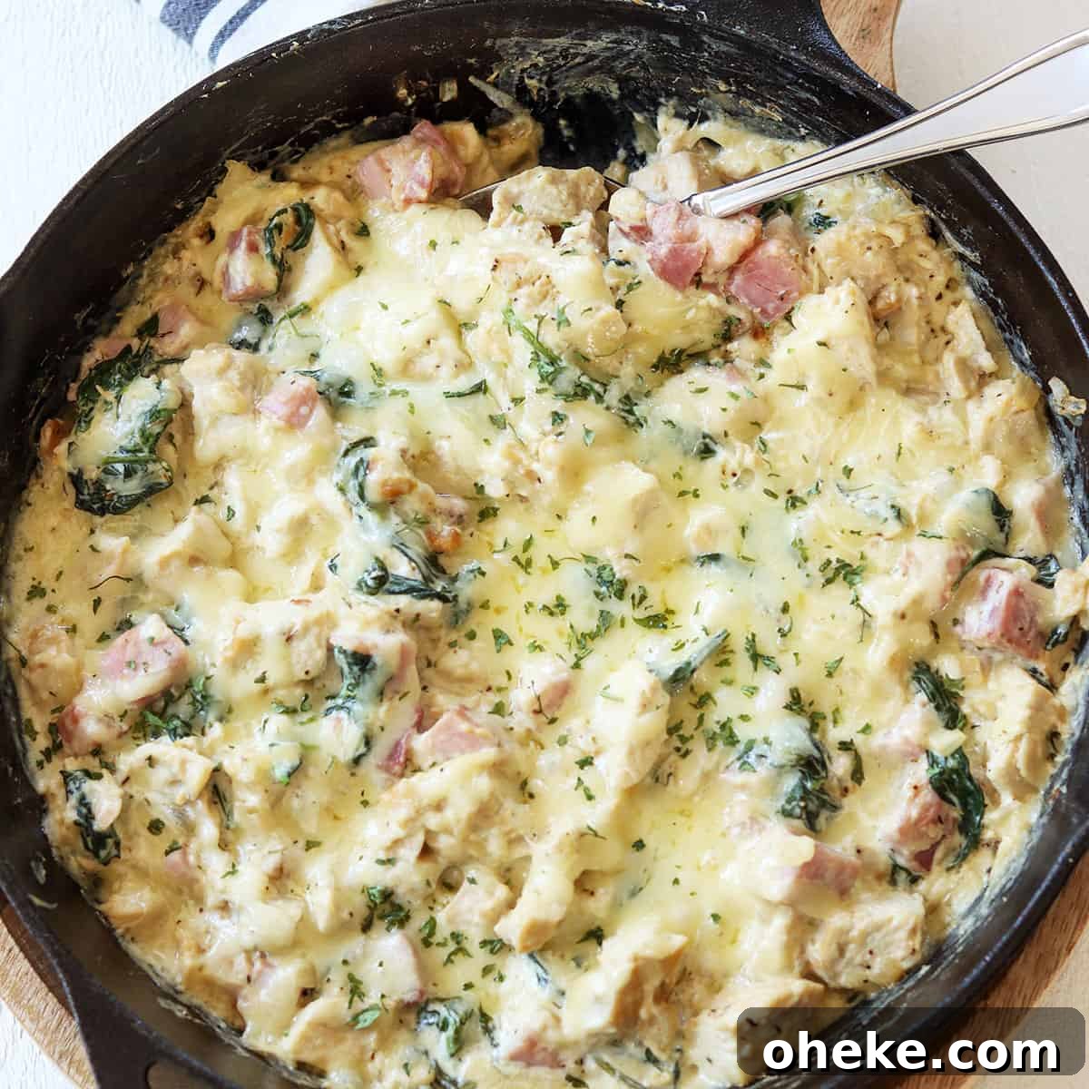 Cordon bleu casserole in a skillet ready to be served. Garnished with fresh parsley.