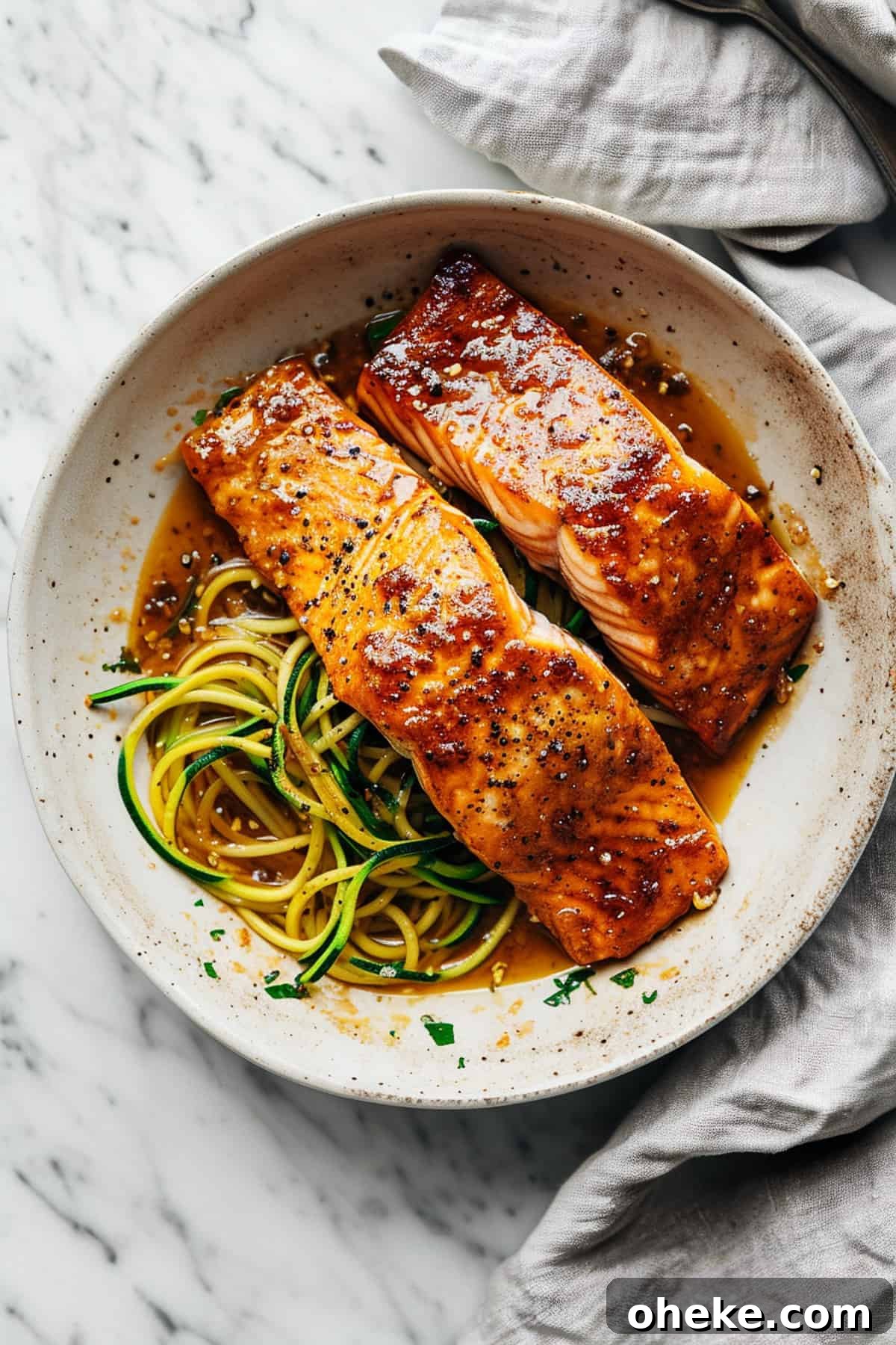 Maple-Glazed One-Pan Salmon Recipe for Quick Weeknight Meals 2 Maple glazed salmon in a pan with zucchini noodles.