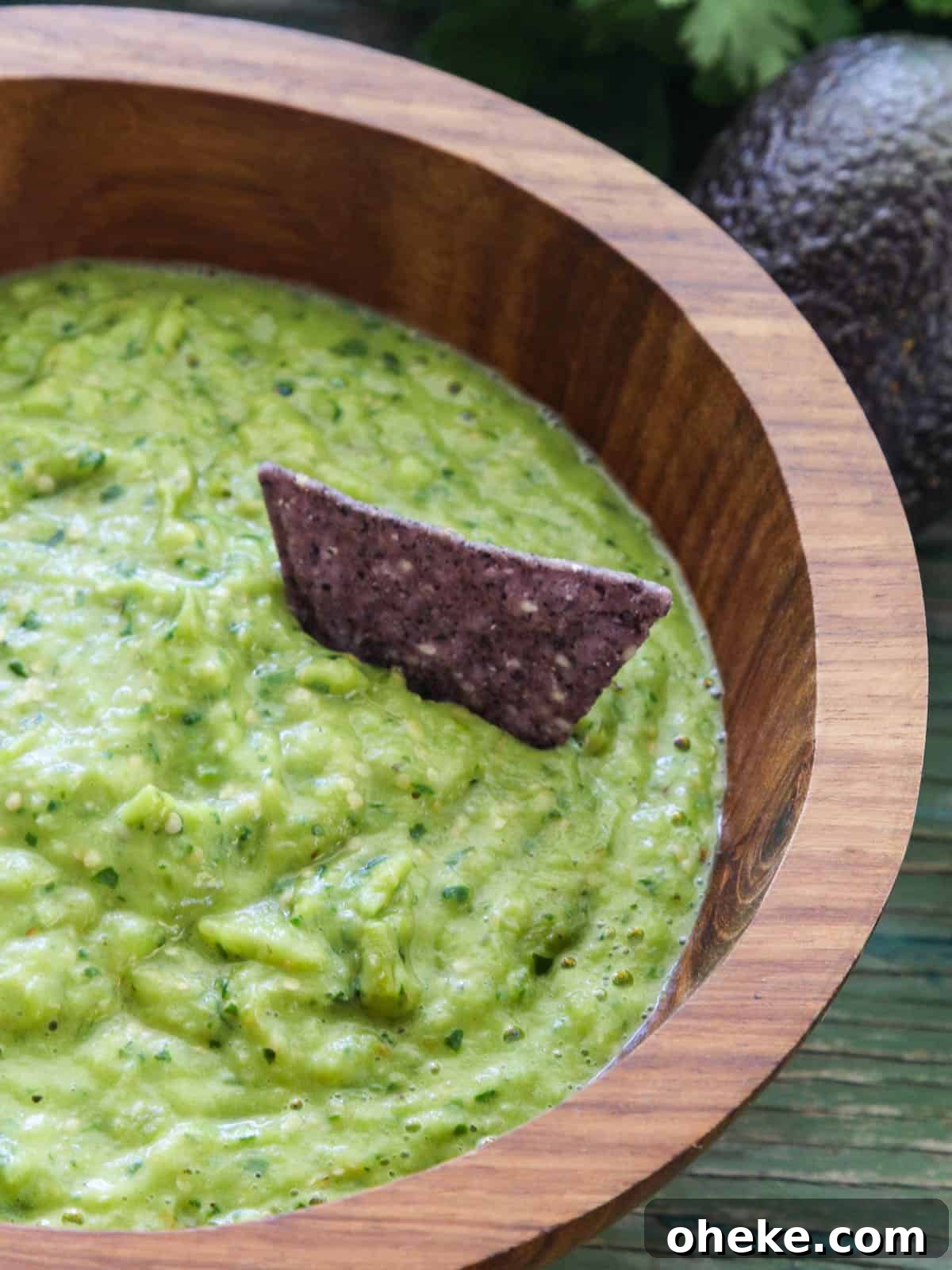 Bowl of avocado salsa and a blue corn chip