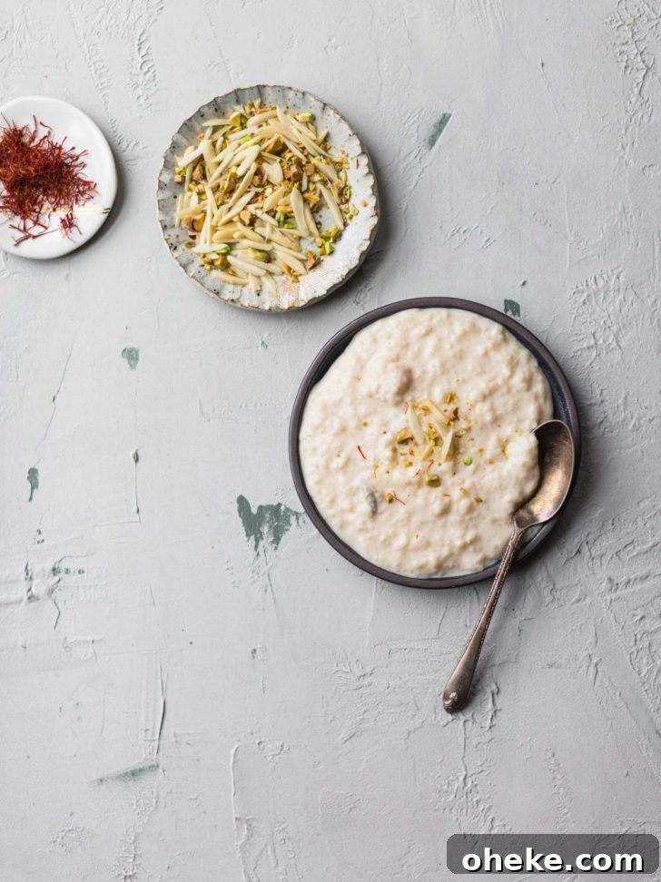 Creamy Instant Pot Kheer Recipe – Quick & Authentic Guide 2 Kheer on a dark plate with a spoon along with pistachios and almonds and saffron strands