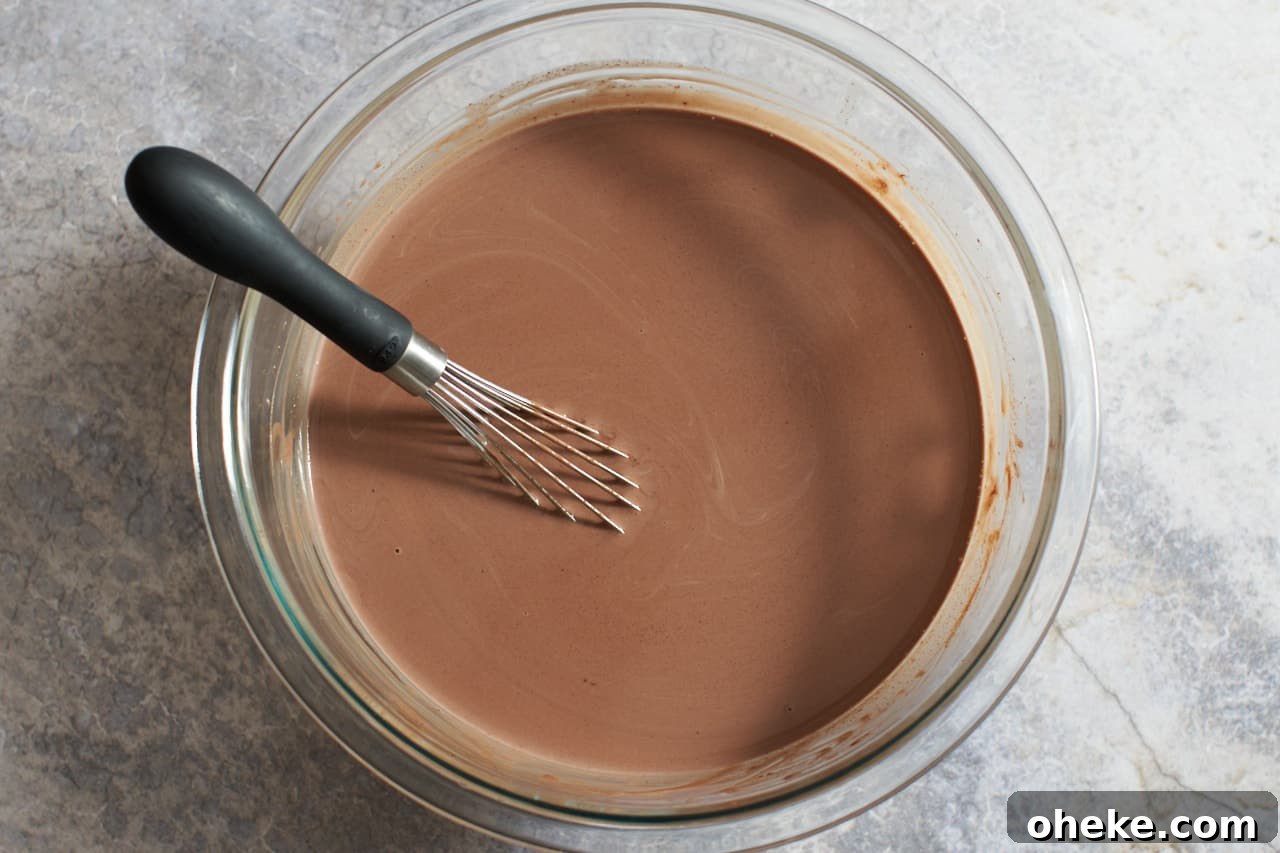 Chocolate Pots de Crème: Simple Stove-Top Method for Rich Dessert 5 A bowl of melted chocolate and heavy cream with a whisk in it.