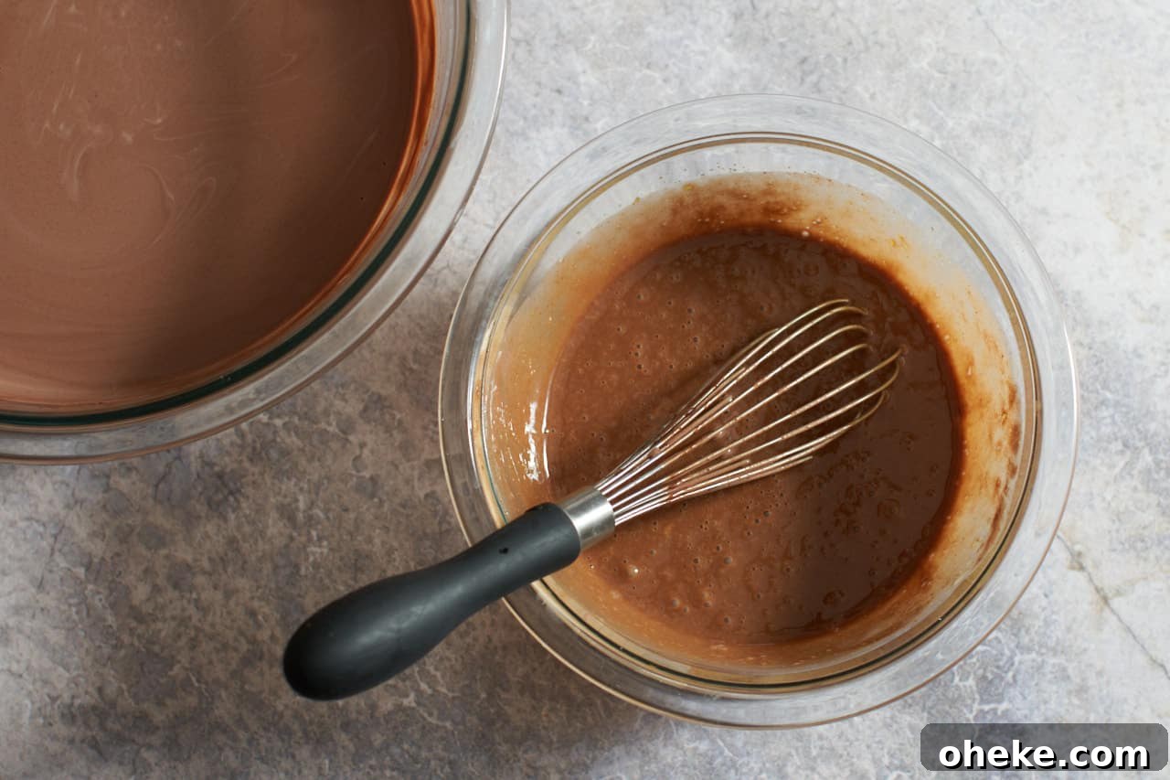 Chocolate Pots de Crème: Simple Stove-Top Method for Rich Dessert 7 A whisk in a bowl of eggs mixed with warm chocolate. A large bowl of melted chocolate is on the left.