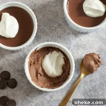 Chocolate Pots de Crème: Simple Stove-Top Method for Rich Dessert 9 Three chocolate pots de creme with whipped cream on top. Chocolate wafers are on the left, a spoon with chocolate on it is on the right.