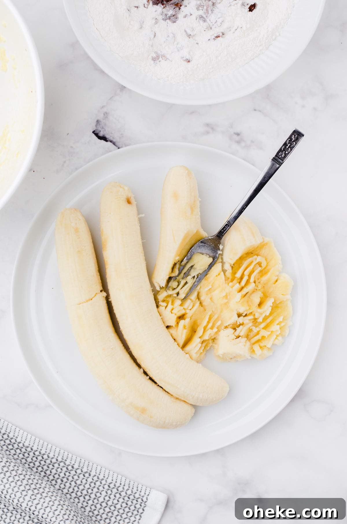 Moist Buttermilk Banana Bread Recipe with Brown Butter Glaze 6 Mashed bananas on a plate for buttermilk banana bread.