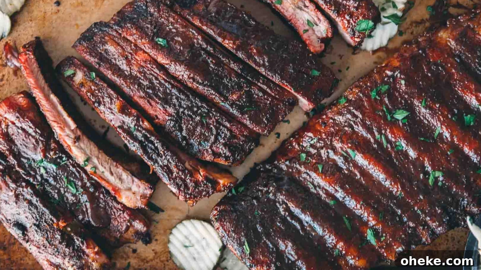 Smoked pork spare ribs with a glossy glaze stacked on a tray.