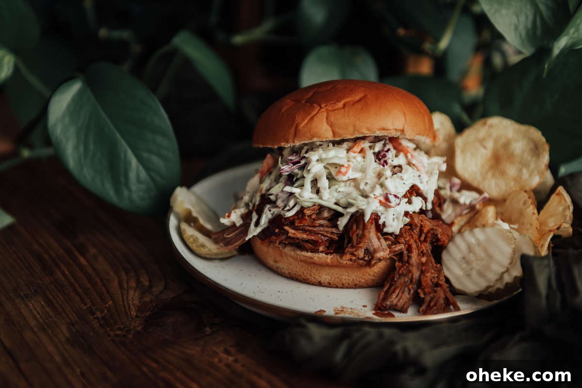 Slow Cooker pulled pork on a bun with slaw and pickles.