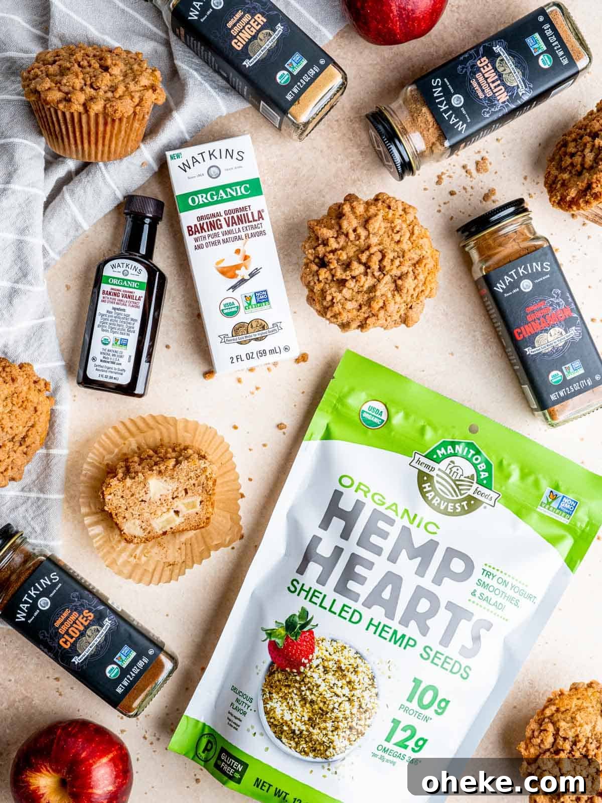 Top view of apple streusel muffins, Watkins baking vanilla, and Manitoba Harvest hemp hearts