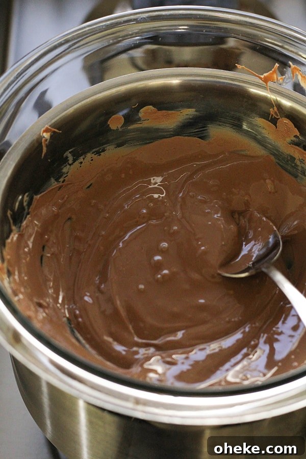 Crunchy Chocolate-Covered Almonds Recipe for Homemade Snacks 7 melted chocolate in a glass bowl.