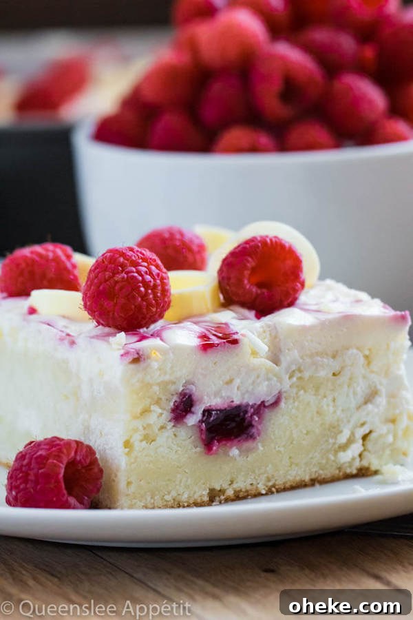 slice of white sheet cake with raspberries on top