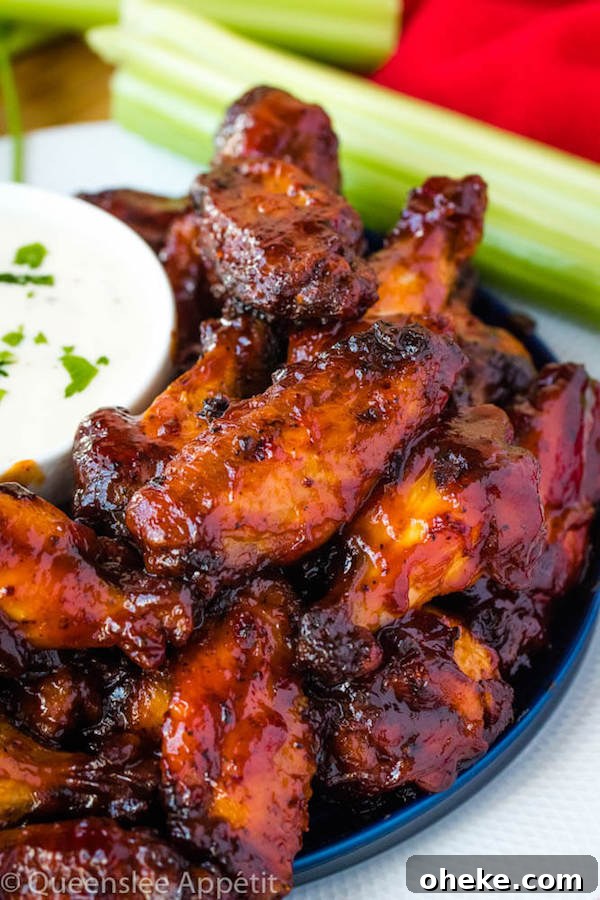 honey barbecue flavoured chicken wings on a blue plate with ranch dipping on the side