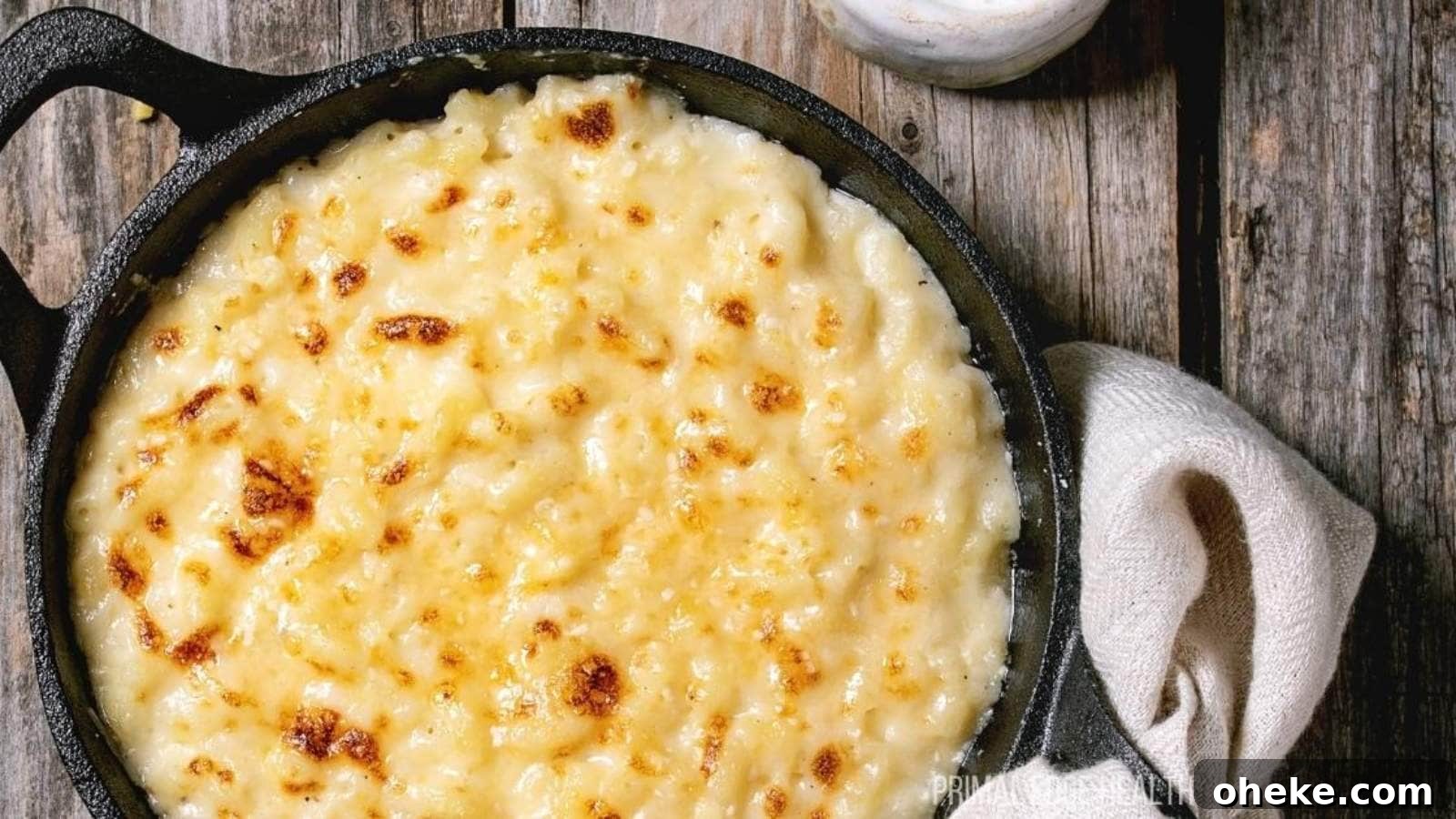 17 Comforting Recipes to Keep You Warm This Season 11 A picture of baked cauliflower mac and cheese in cast iron skillet on wooden table.