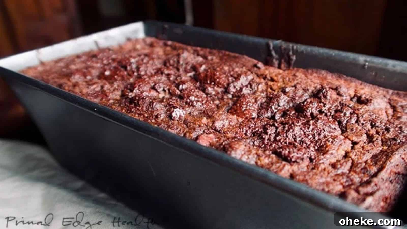 17 Comforting Recipes to Keep You Warm This Season 12 A close-up of a freshly baked loaf of chocolate pumpkin bread in a black metal pan.