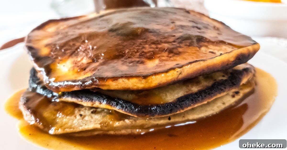 17 Comforting Recipes to Keep You Warm This Season 15 A stack of pancakes with pumpkin spice syrup on a plate.