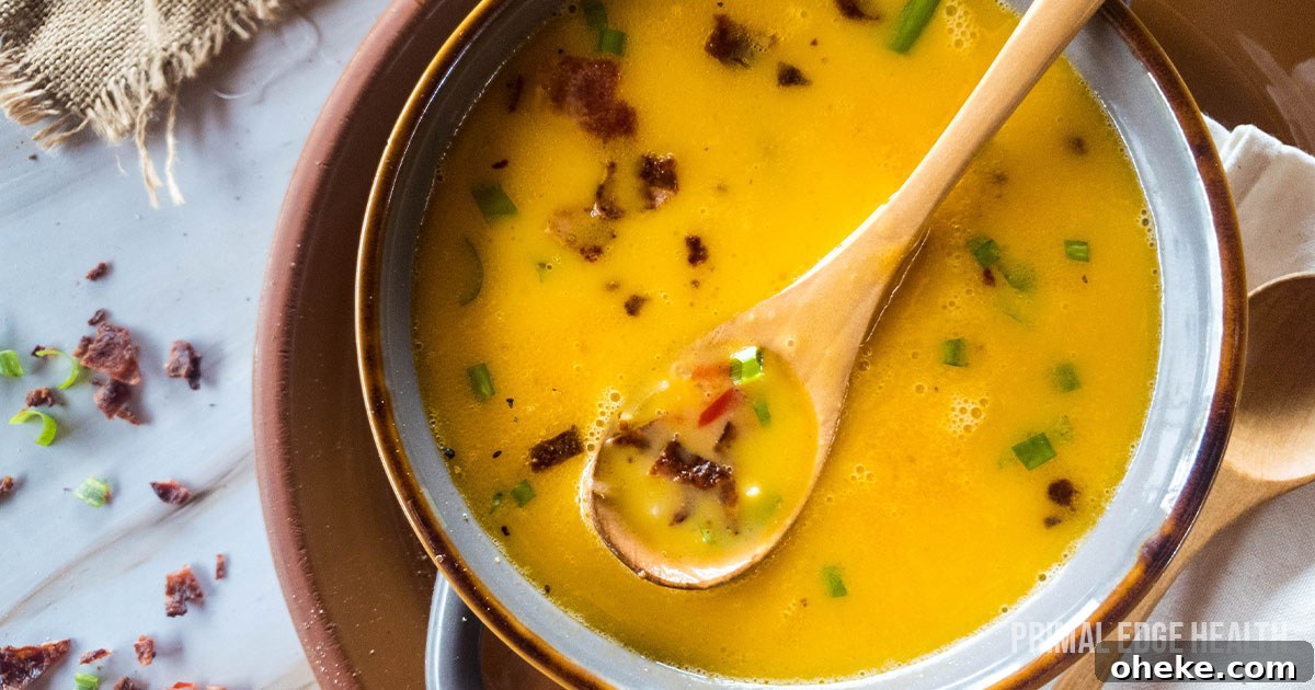 17 Comforting Recipes to Keep You Warm This Season 4 Beer cheese soup with wooden spoon in a bowl.