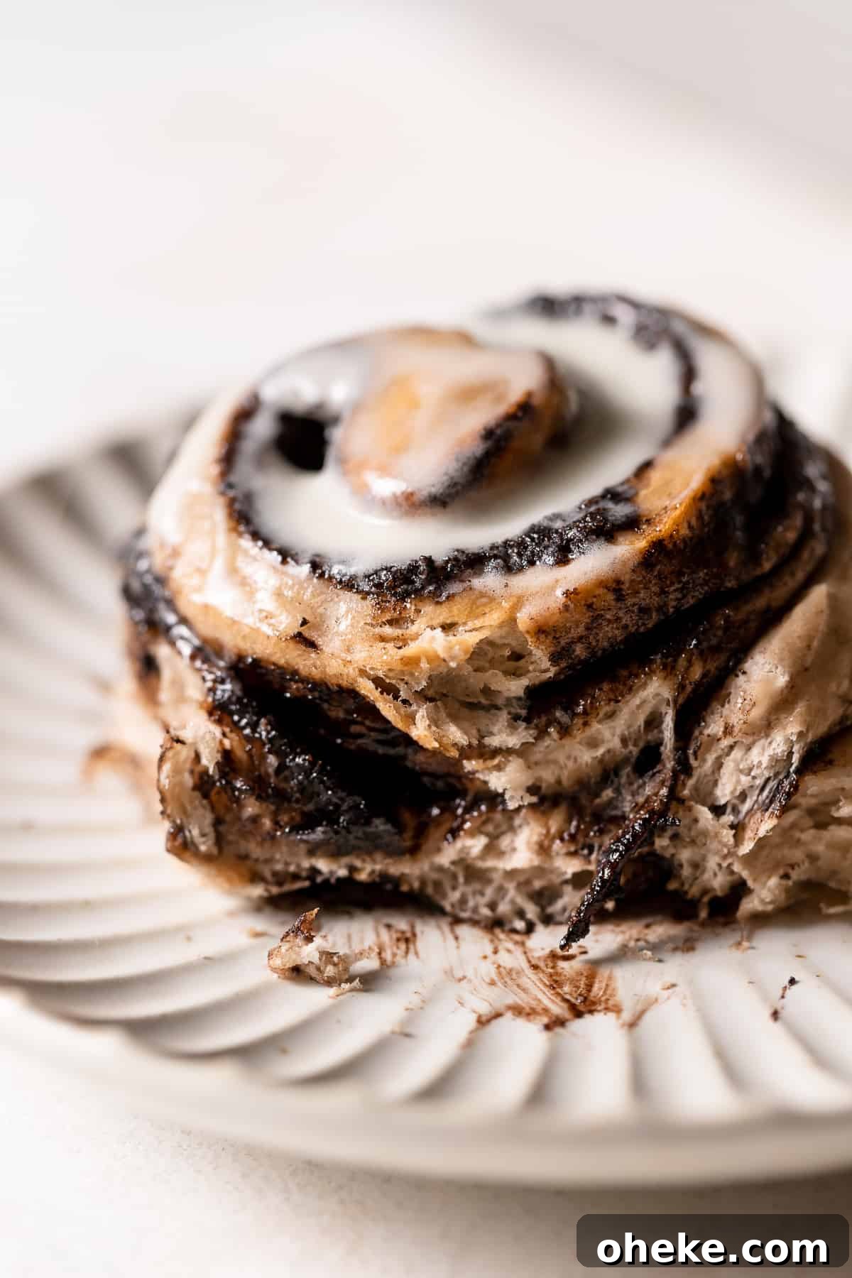 Cookies and Cream Cinnamon Rolls Recipe for Dessert Lovers 2 Oreo cinnamon roll on a plate with some of the chocolate filling oozing out.