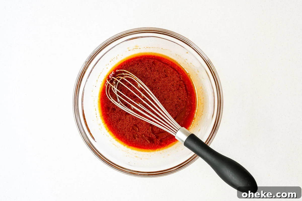 Spicy Gochujang Korean Noodles Recipe 6 Gochujang noodle sauce in a small glass bowl with a whisk.