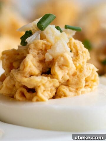 A deviled egg topped with fresh Dungeness crab and chive.