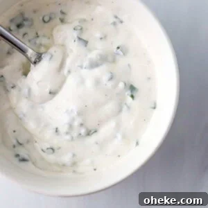 Creamy Horseradish Yogurt Sauce With 3 Simple Ingredients 10 Close up of Horseradish Yogurt Sauce in a white bowl with a spoon.