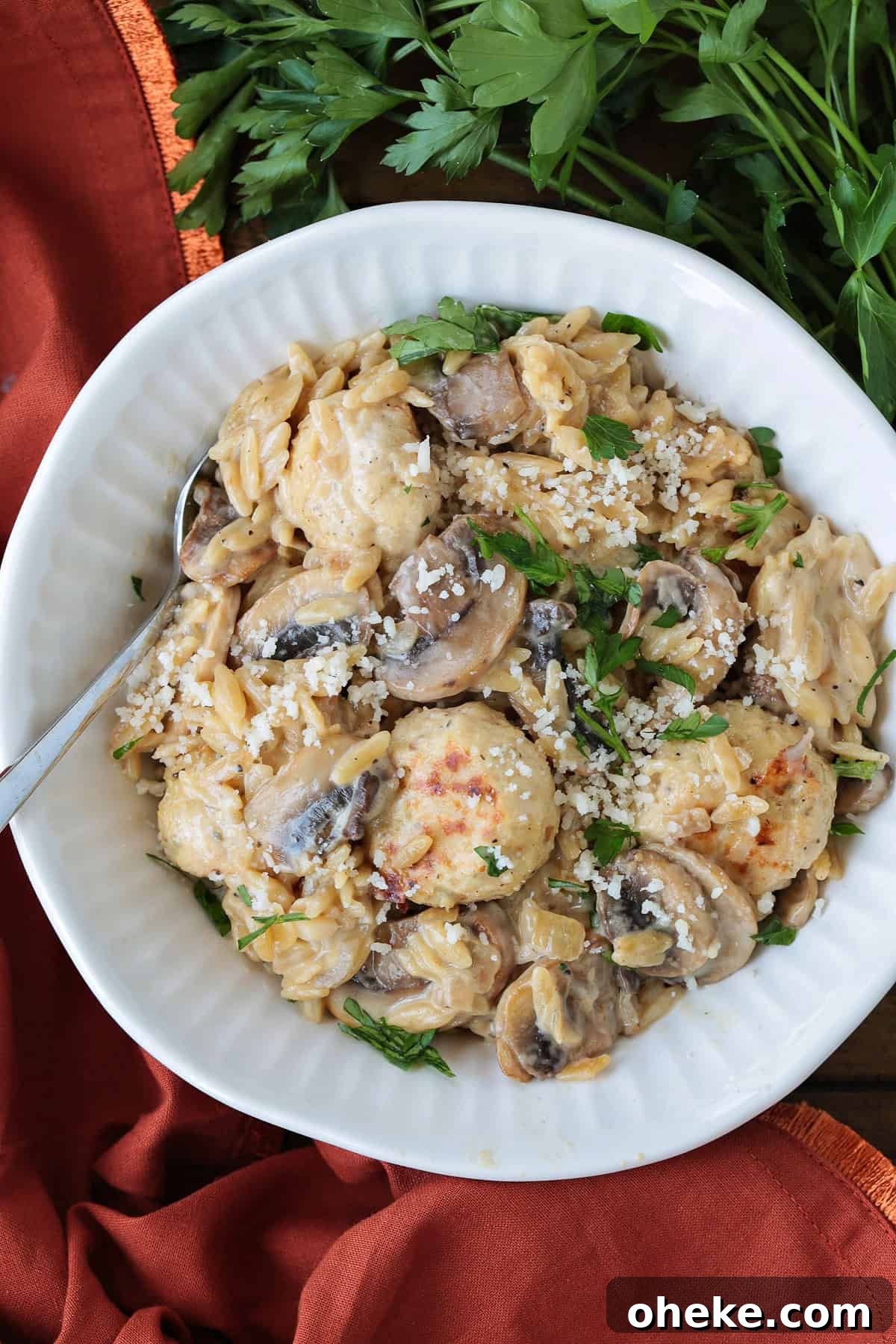 white bowl with chicken meatballs and mushroom orzo with parsley