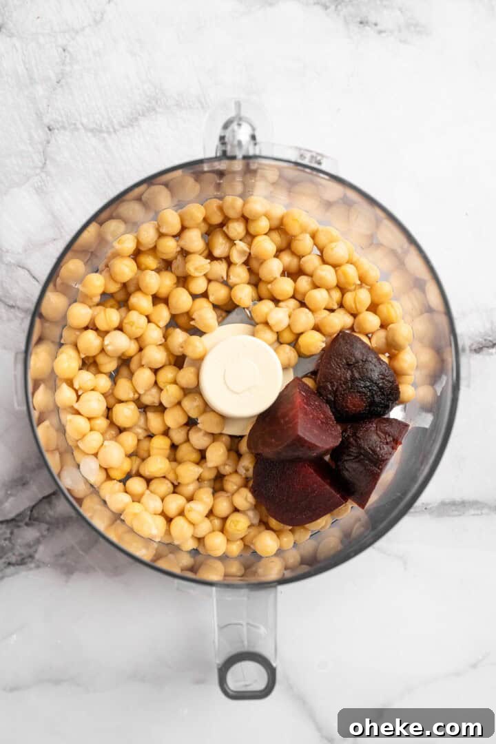 Pulse beets and chickpeas. Overhead view of roasted beets and chickpeas in food processor bowl