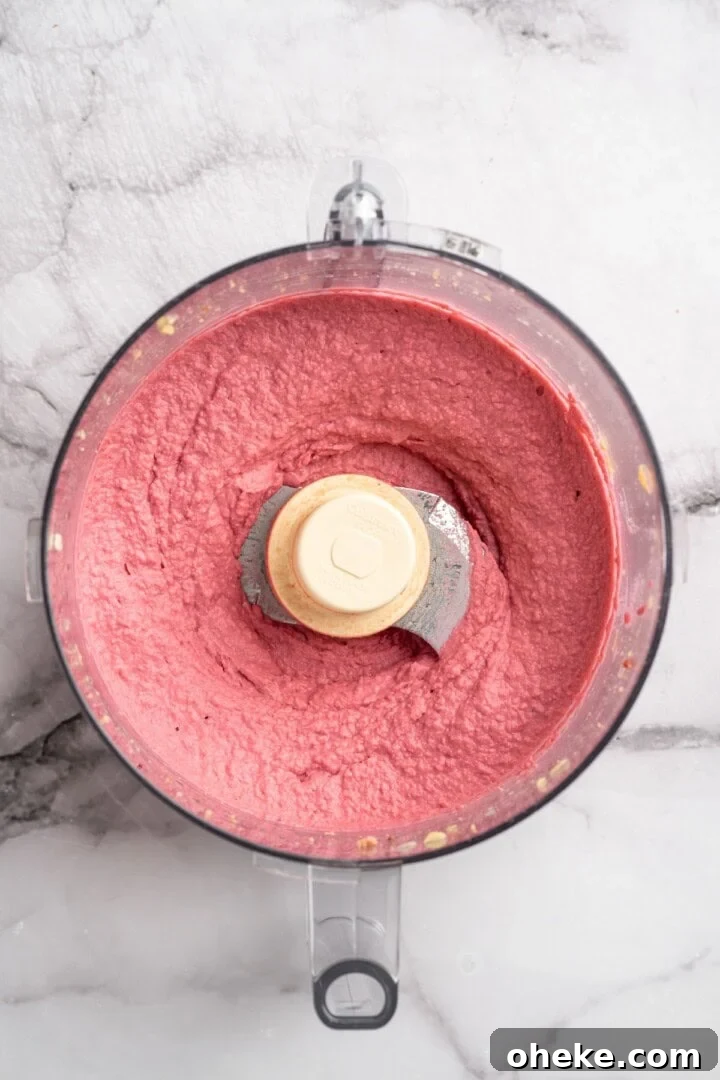 Blend. Overhead view of beet hummus in food processor