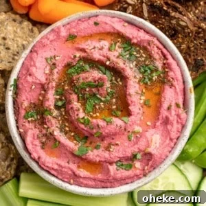 Creamy Beet Hummus Recipe: Vibrant, Smooth Beetroot Dip 2 Bowl of beet hummus on platter with crudite and crackers