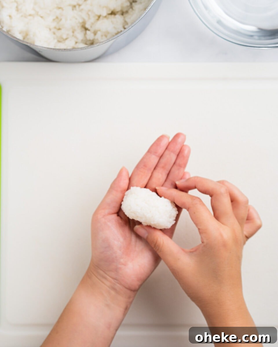 How to Make Gunkan Sushi: Step-by-Step Recipe and Tips 6 Hands shaping a small mound of rice. Rice and water bowl on the side.