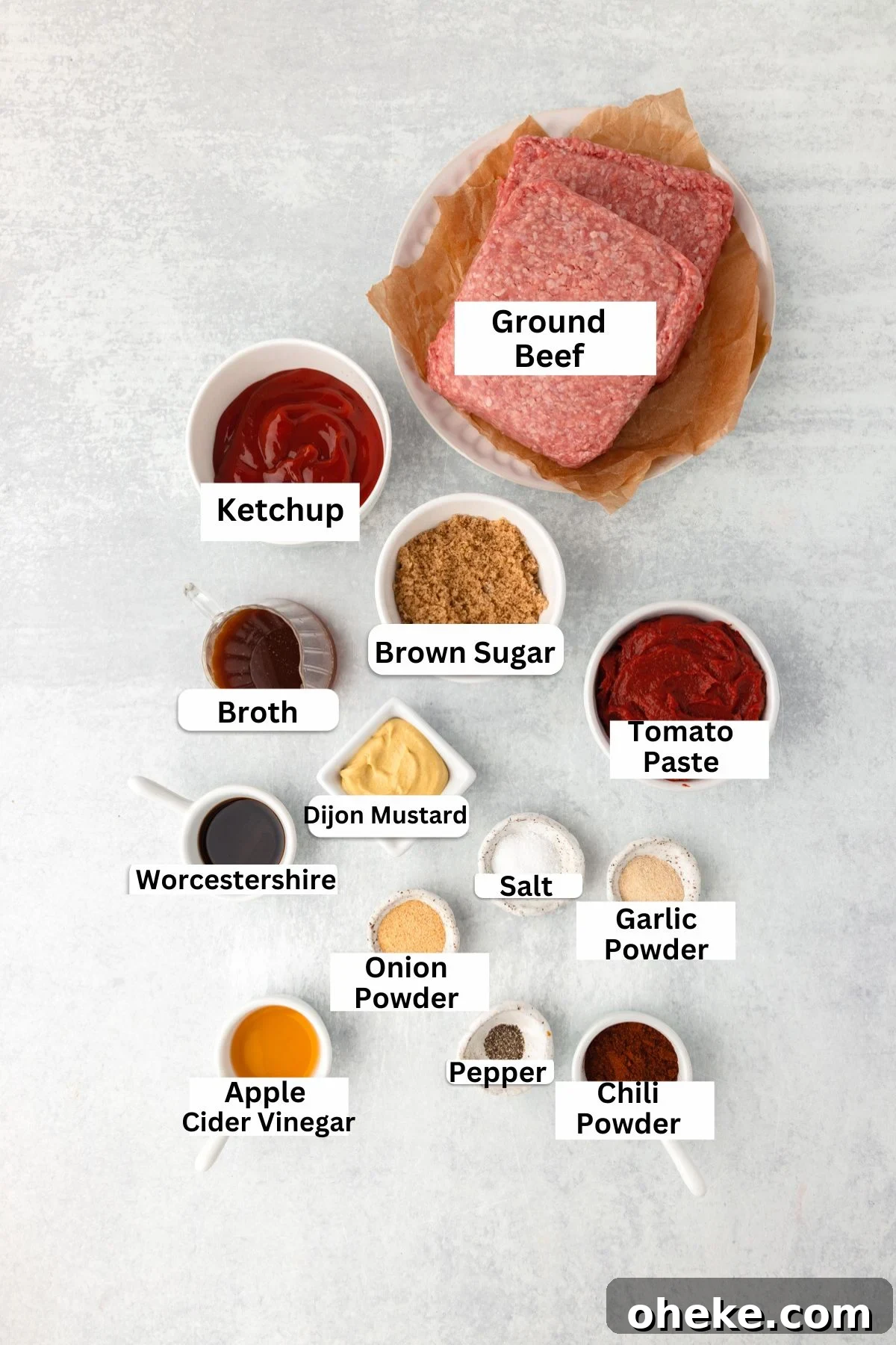 Slow Cooker Sloppy Joes Recipe for Tender, Flavorful Sandwiches 3 Top-down view of labeled ingredients for a recipe, including ground beef, ketchup, brown sugar, tomato paste, broth, Dijon mustard, Worcestershire, seasonings, and apple cider vinegar, arranged on a light surface.
