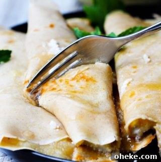 Apple Sauce Crepes With Honey Ricotta Filling 6 Fork cutting through crepe with apple sauce and ricotta with honey