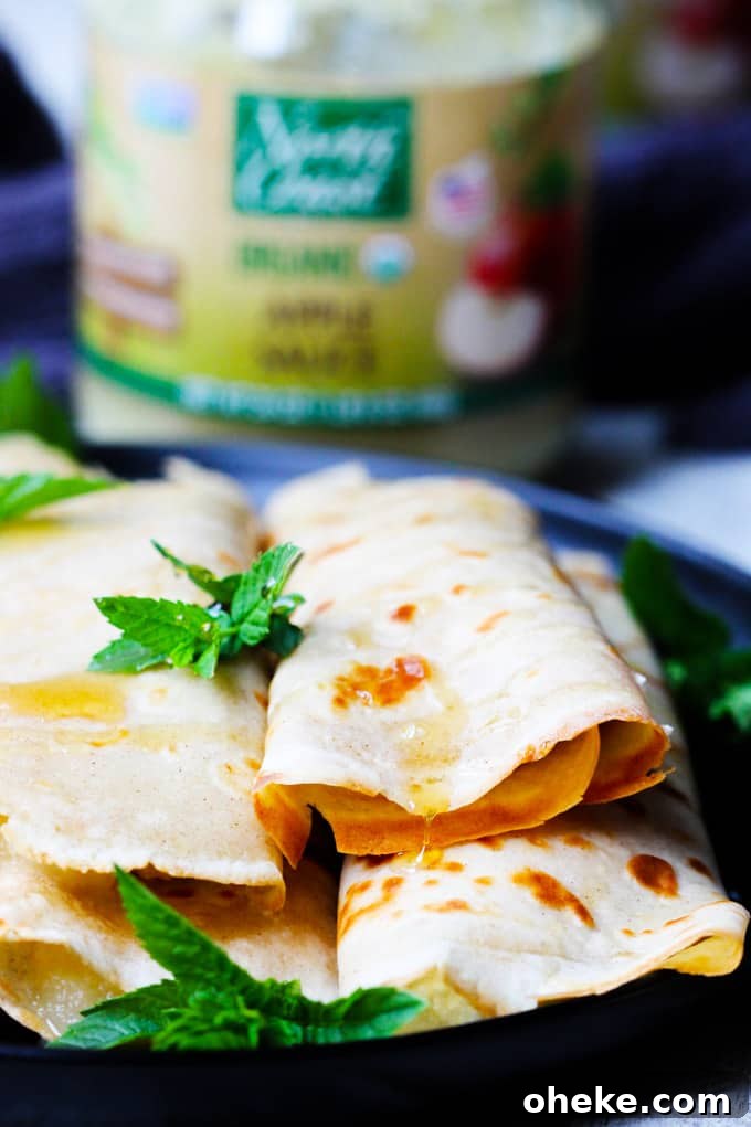 These Apple Sauce Crepes with Honey Ricotta are made with cinnamon crepes, North Coast Organic Apple Sauce, organic ricotta and raw honey. These crepes are super delicious and healthy at the same time. A perfect option for a school lunch or even an afternoon snack. Crepes with Apple Sauce and Honey Ricotta on a plate
