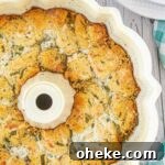 Savory Garlic Pull-Apart Bread Recipe 12 Overhead close up shot of Italian monkey bread in a bundt pan - cropped square.