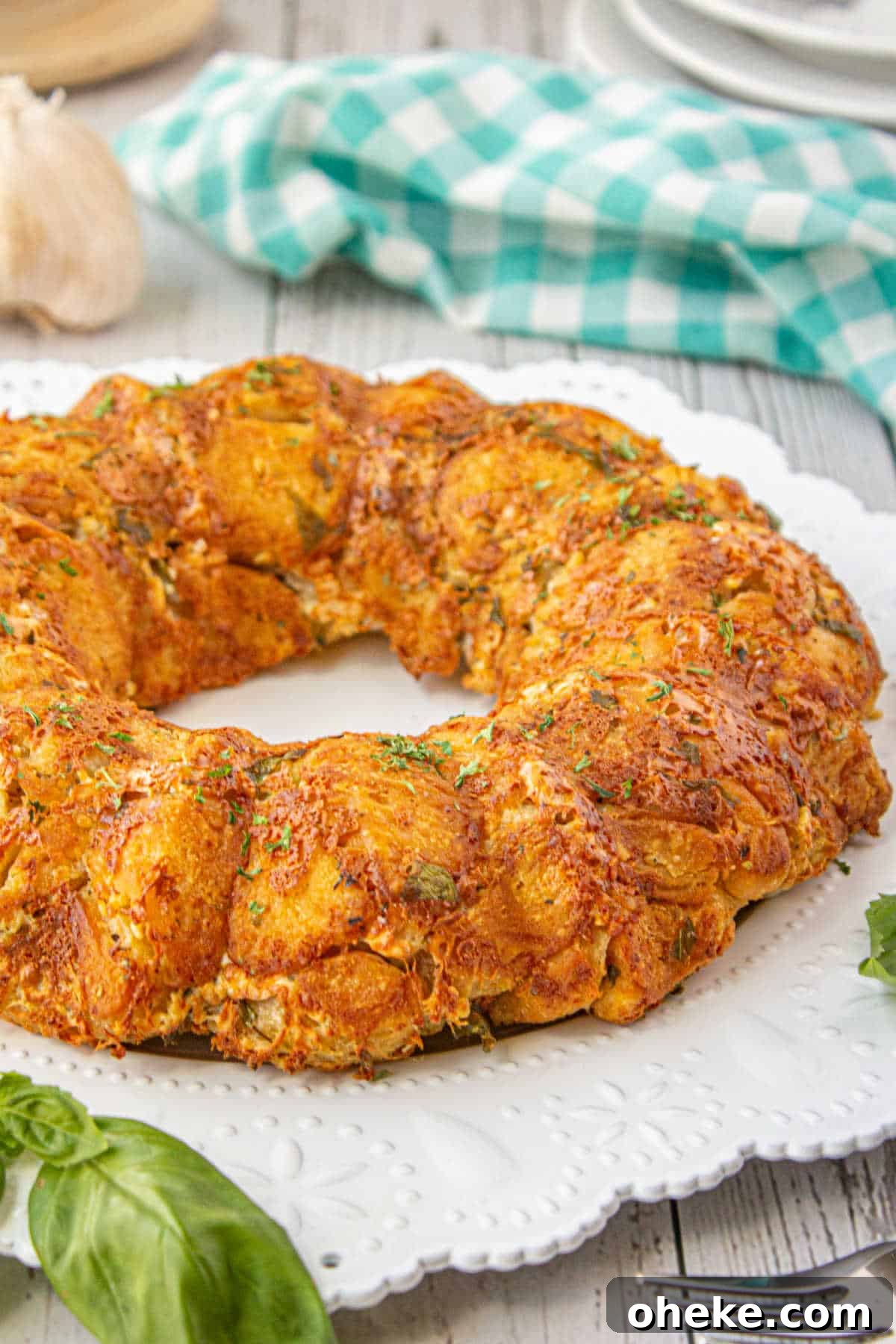 Savory Garlic Pull-Apart Bread Recipe 9 Italian monkey bread on a plate with some basil.