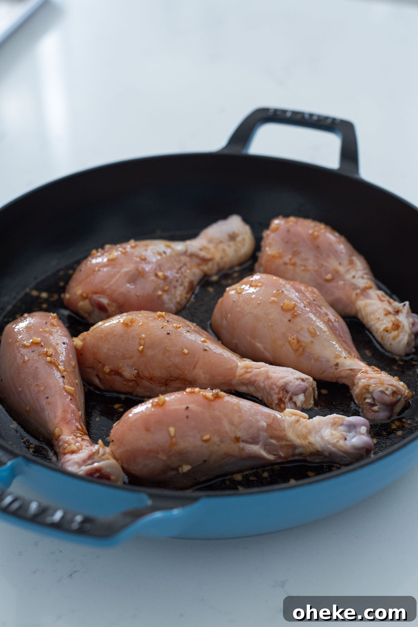 Skillet chicken drumsticks cooking in homemade teriyaki sauce.