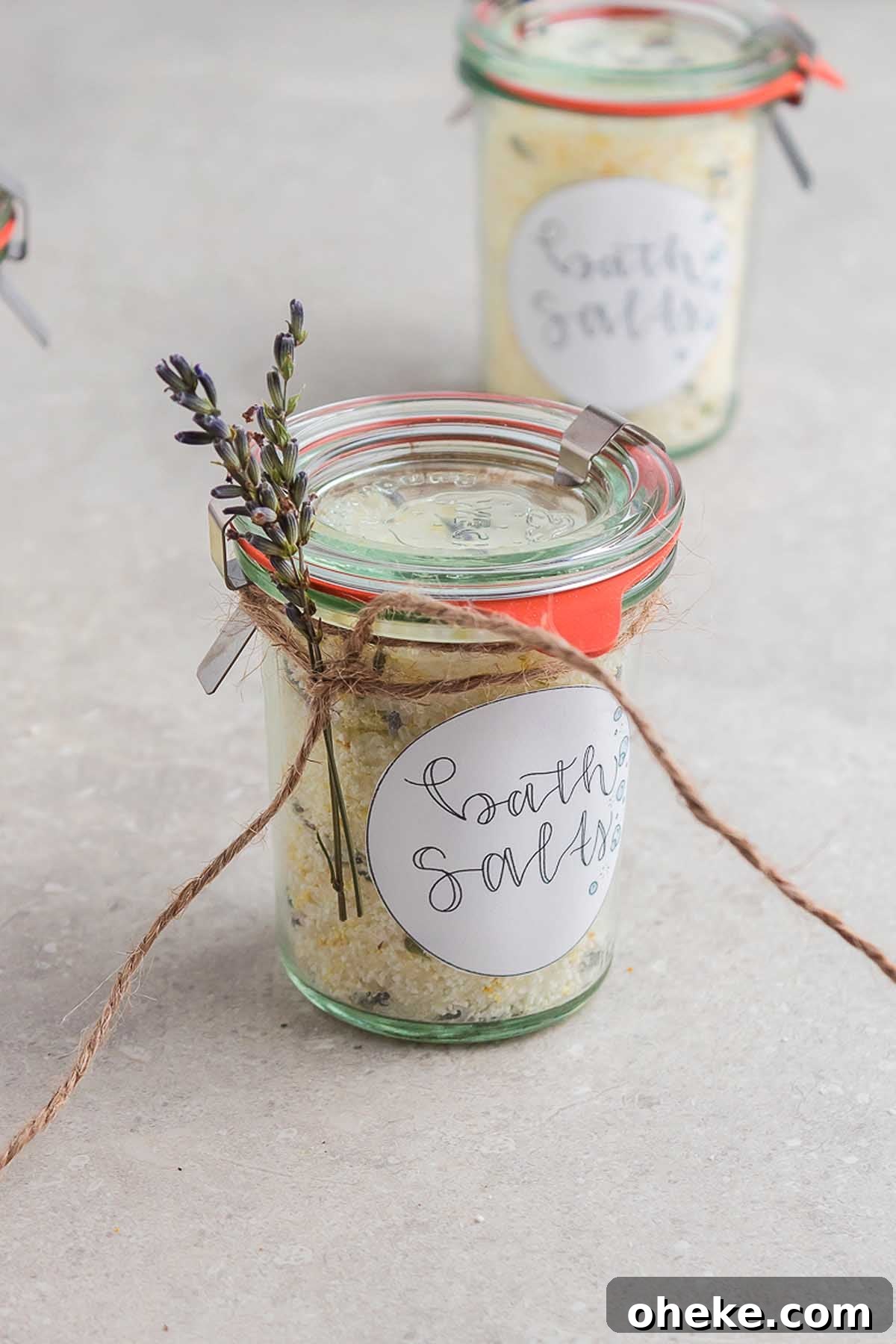 Small jars of bath salts with lavender tied to them.