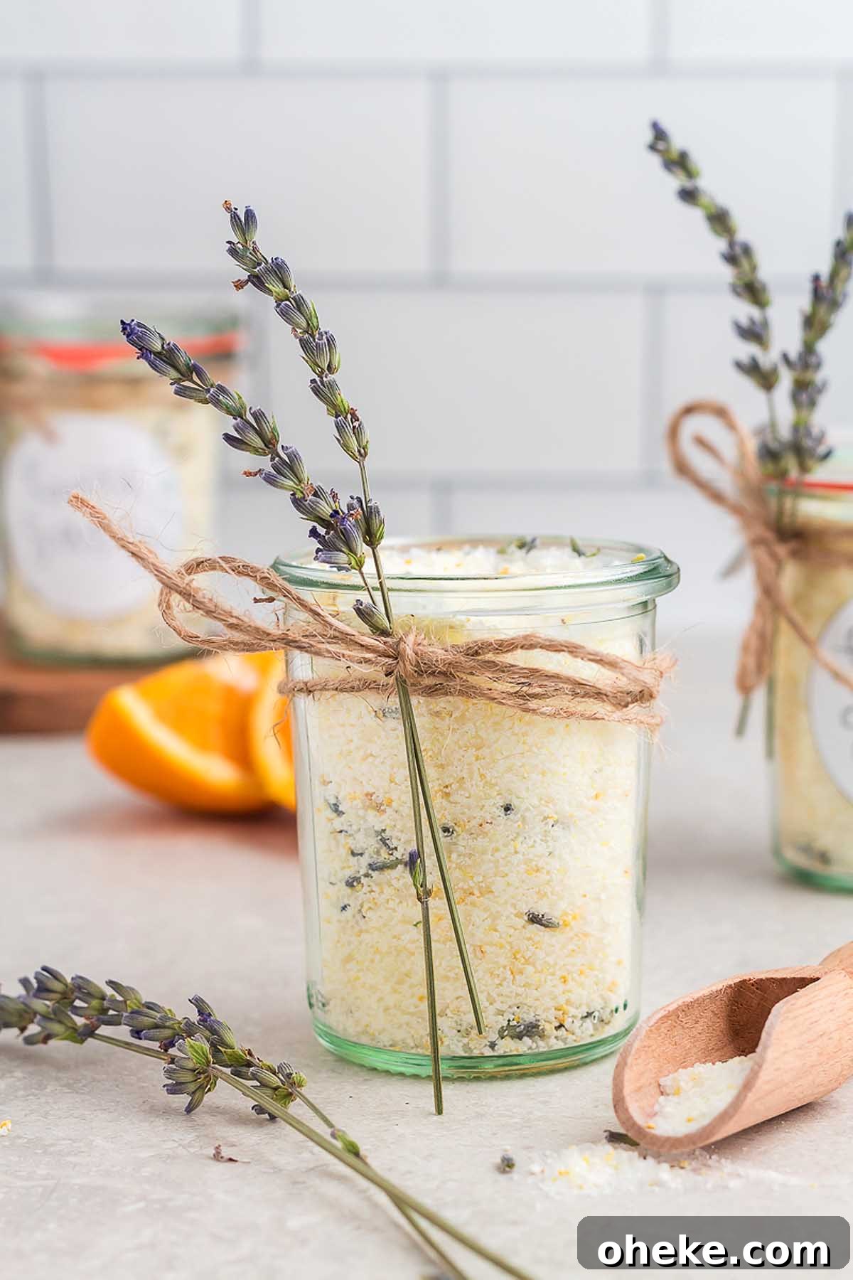 Three jars with lavender and orange sprigs, perfect for creating a DIY herbal bath salts recipe.