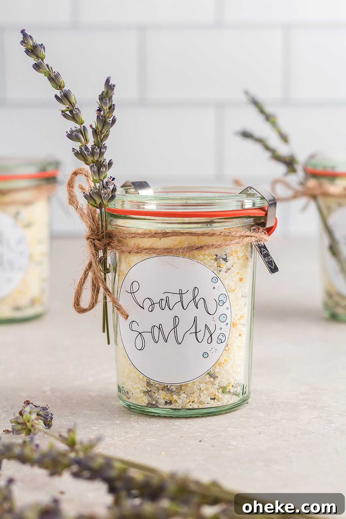 Homemade bath salts in glass jars with lavender flowers.