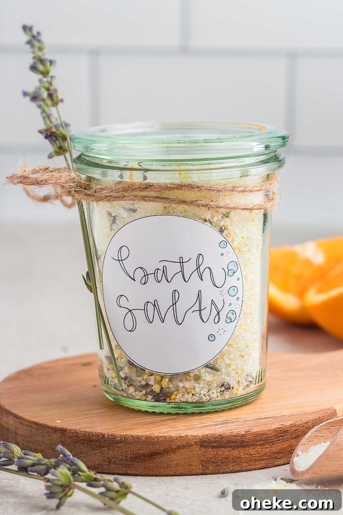 A jar of homemade lavender-orange bath salts on a wooden cutting board.