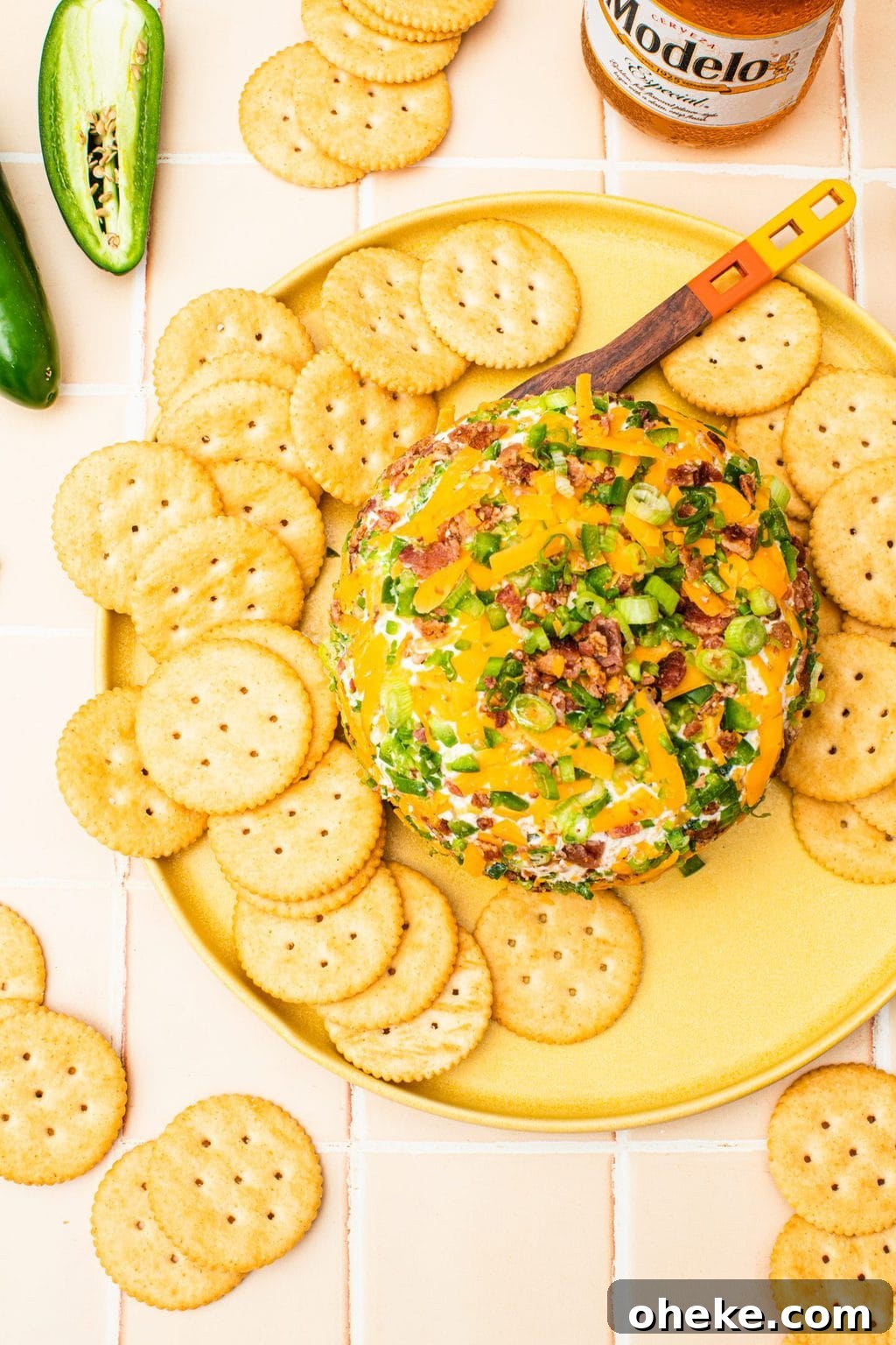 jalapeno cheese ball on yellow platter with butter crackers