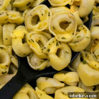 Large Spoonful of One Pot Cheese Tortellini Recipe with Garlic Butter Sauce.