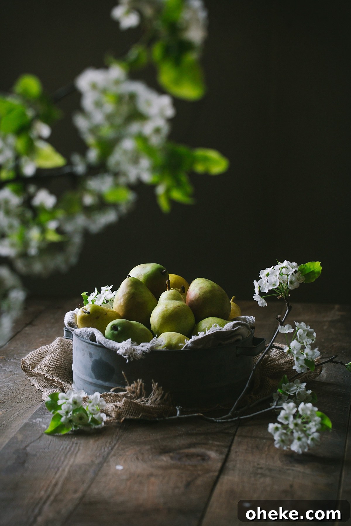 arrangement of pears with pear blossoms in foreground