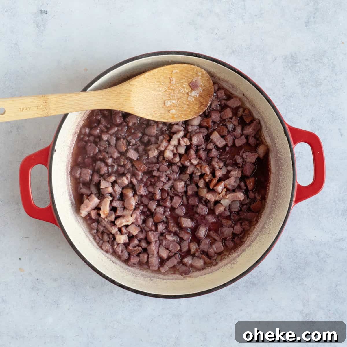 Red wine added to bacon and garlic in pan.
