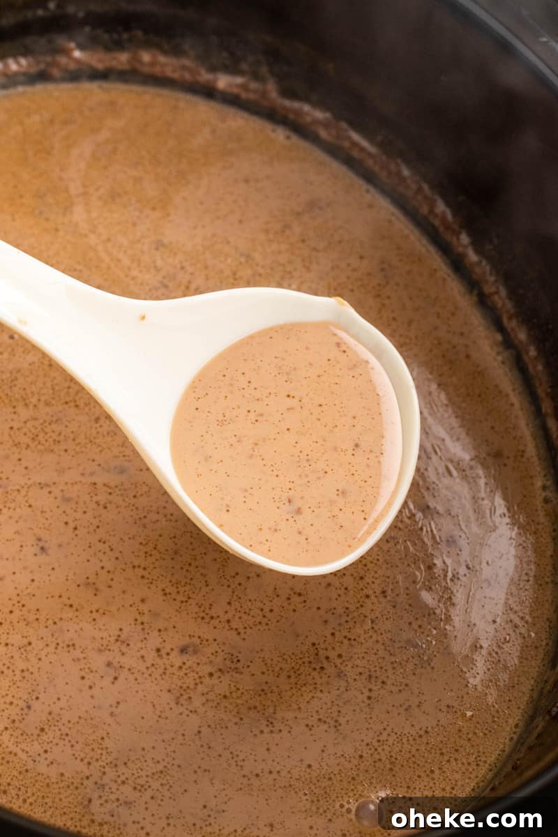 scooping hot chocolate out of the slow cooker