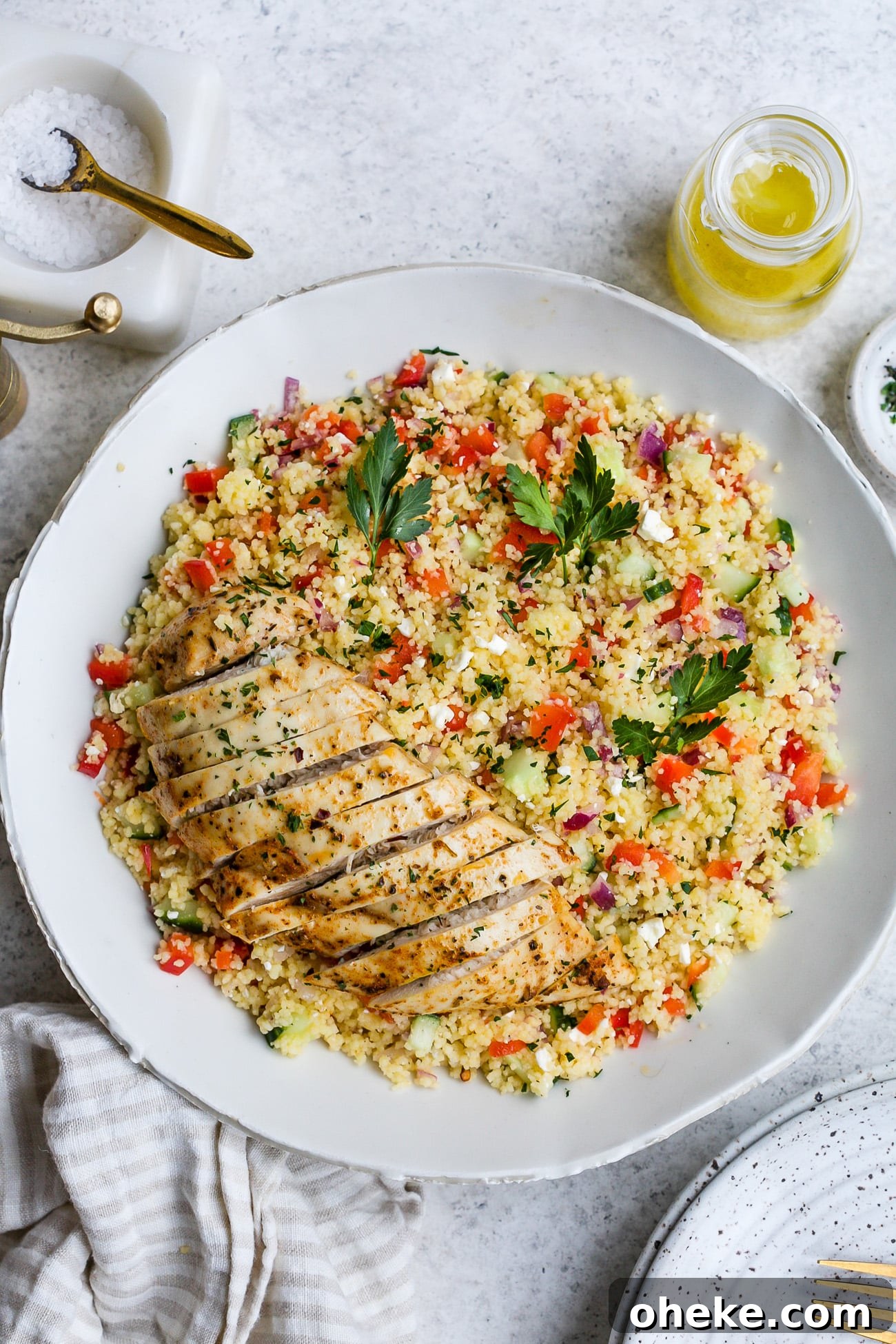 Chicken couscous salad in a large, white serving bowl.
