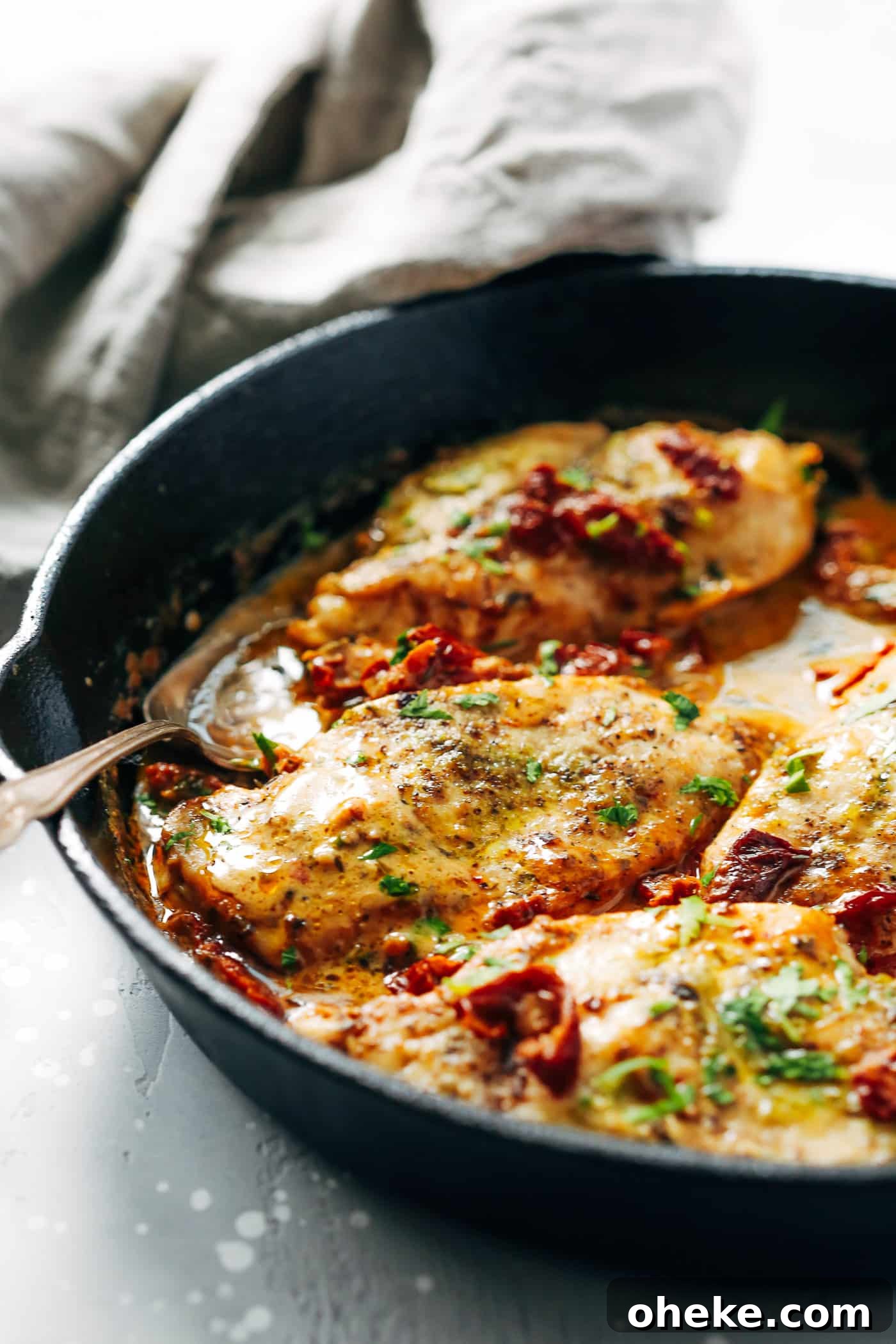 Creamy parmesan chicken in a cast iron skillet. 