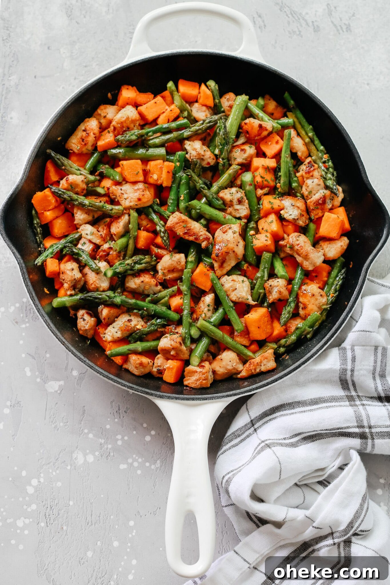Asparagus Sweet Potato Chicken in a cast iron Skillet.