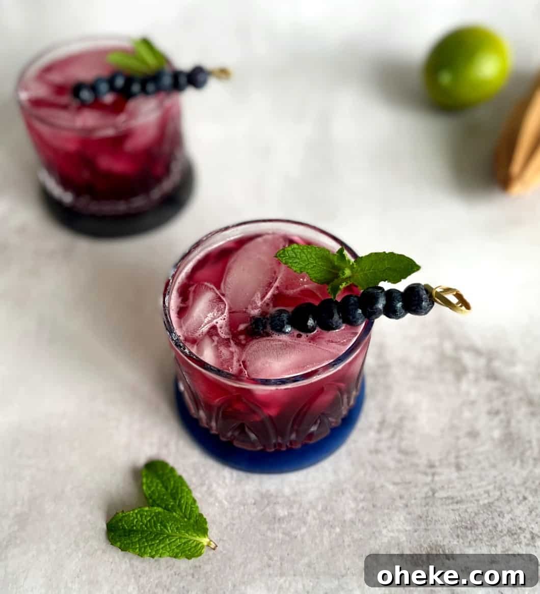 gin and tonic with blueberry syrup.