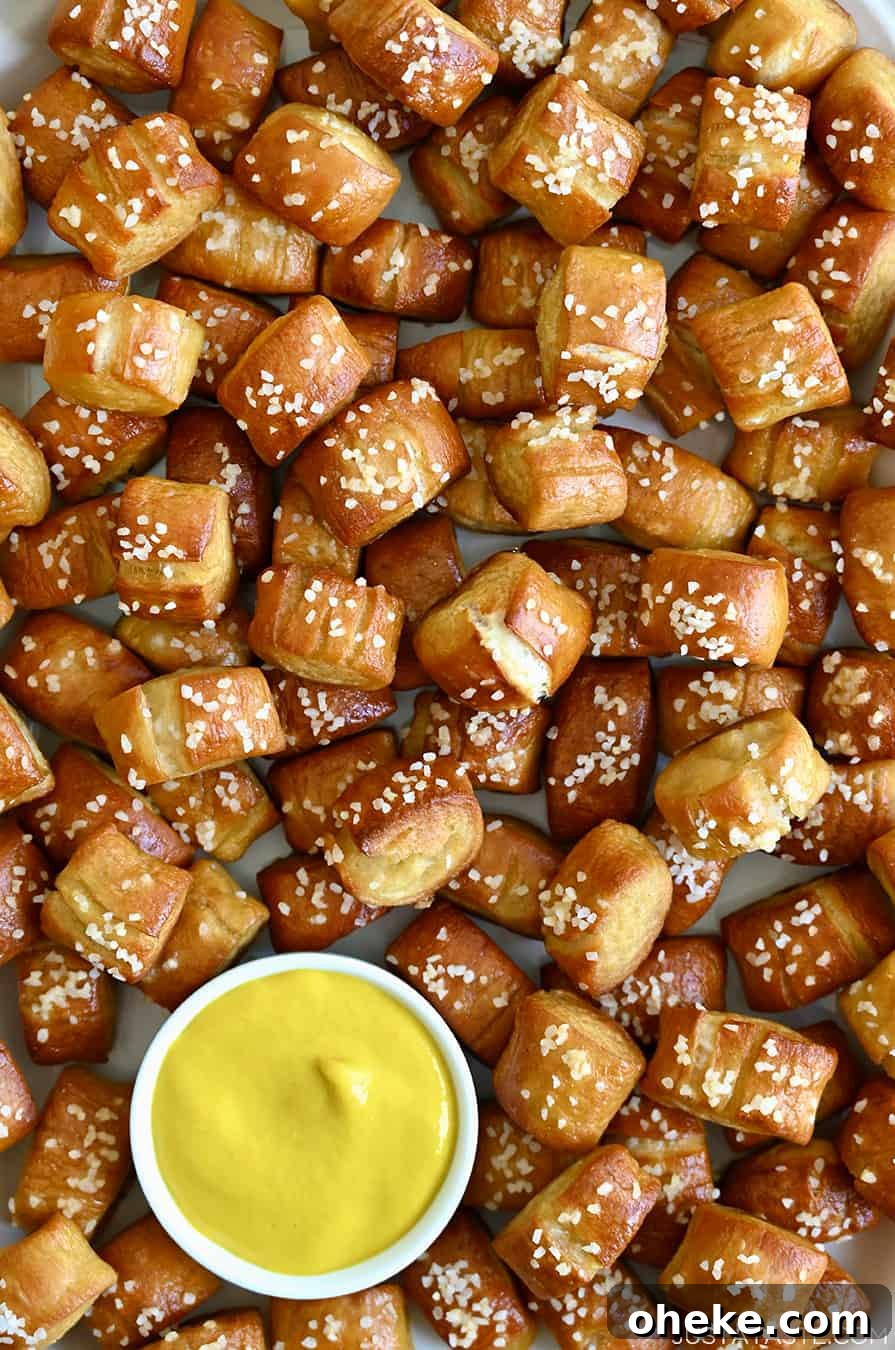 A close-up view of Easy Homemade Soft Pretzel Bites surrounding a small ramekin filled with yellow mustard